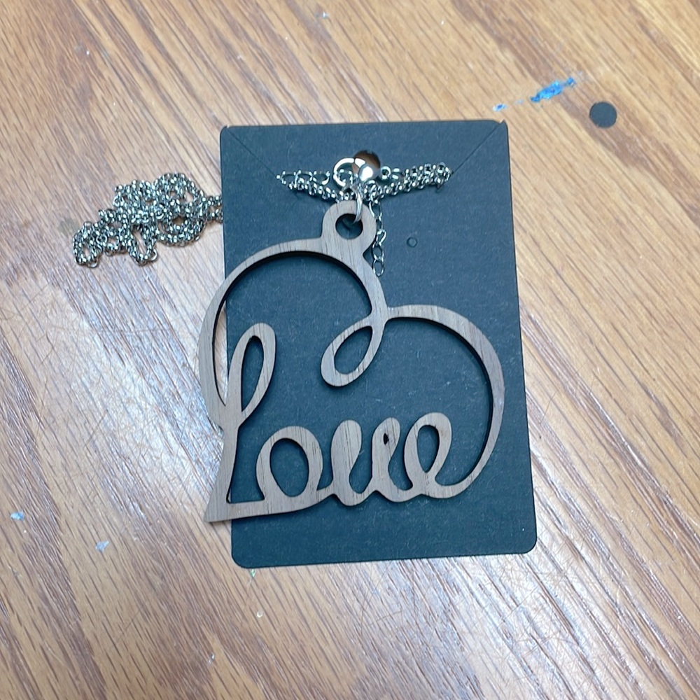 Brand new necklace it is a laser wood that is cut in the shape of a heart.